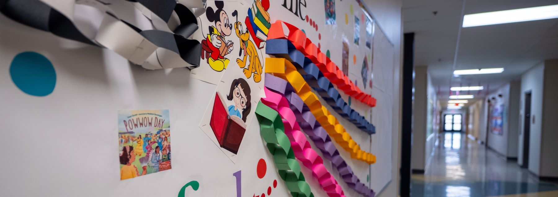 School hallway decorated with colorful paper streamers and festive decorations, creating a vibrant atmosphere.