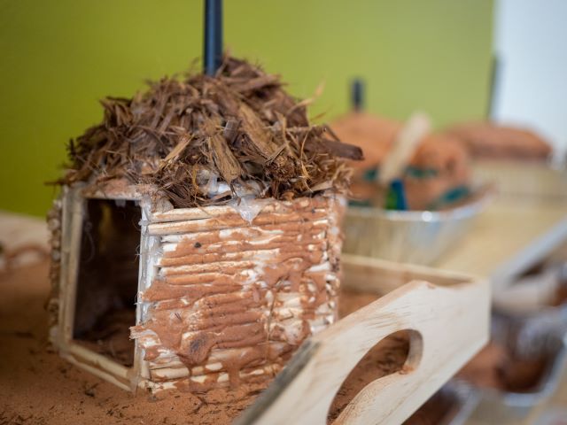 A small model built by a student sits among other projects in the classroom.